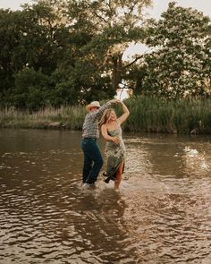 a man and woman are standing in the water with their arms around each other as they dance