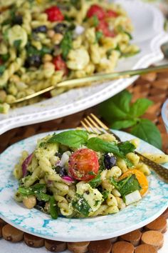 two plates with pasta salad on them