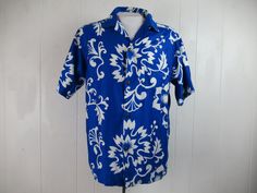 "Vintage 1960s blue and white cotton Hawaiian shirt. Has a matching pattern chest pocket, brass button front, top loop collar button and straight cut hem. Label reads: CREATED IN HAWAII FOR DIAMOND HEAD SPORTSWEAR. Size large. Measurements are: 45\" around the chest 45\" around the waist 18\" shoulder seam to shoulder seam 30\" overall length In very good condition." Blue Fitted Hawaiian Shirt For Beach, Fitted Blue Hawaiian Shirt For Beach, Retro Blue Button-up Hawaiian Shirt, Blue Retro Hawaiian Button-up Shirt, Blue Hawaiian Short Sleeve Cotton Shirt, Blue Cotton Hawaiian Short Sleeve Shirt, Blue Fitted Hawaiian Shirt With Short Sleeves, Blue Retro Button-up Camp Shirt, Retro Blue Button-up Camp Shirt