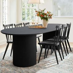 a dining room table with six chairs and a potted plant on the table in front of it