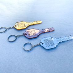 three metal key chains with different designs on them