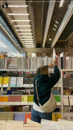 a woman reaching up to reach books in a library