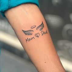 a person with a tattoo on their arm that says mom and dad