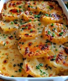 a casserole dish with potatoes covered in cheese and garnished with parsley