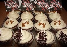 cupcakes with white frosting and brown decorations on top are displayed in front of two packages