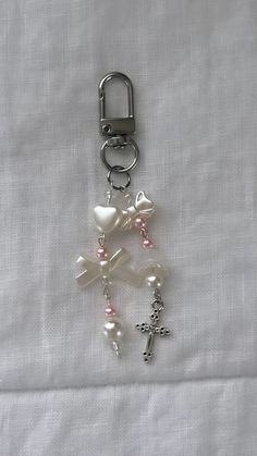 a keychain with charms attached to it on a white cloth covered tablecloth