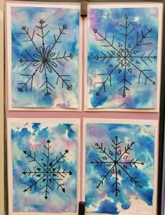 four snowflakes are hanging on the wall with blue and purple watercolors