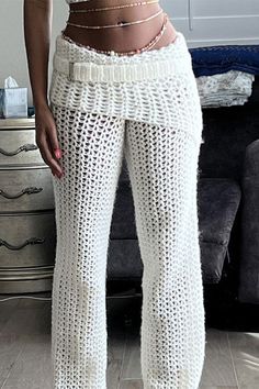 a woman in white pants standing next to a couch