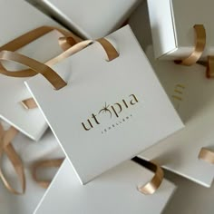 several white boxes with gold ribbons around them and the word utopia written on one side