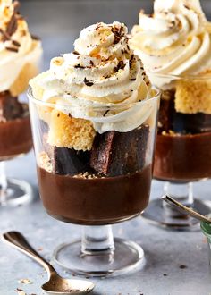 three desserts with whipped cream and chocolate on top are sitting in small glass dishes