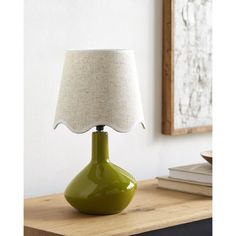 a green lamp sitting on top of a wooden table