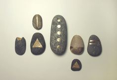 several rocks with different shapes and sizes are arranged on a white surface in the shape of an arrow