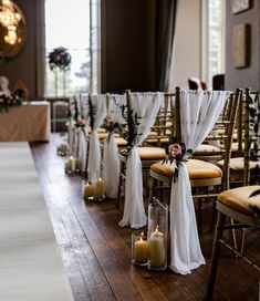 rows of chairs with white draping and candles on the floor in front of them