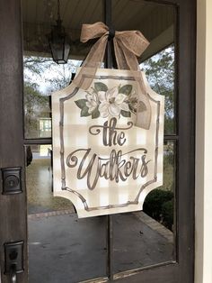 a sign that says the walkers on it hanging from a front door with a bow