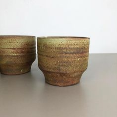 two brown bowls sitting on top of a table