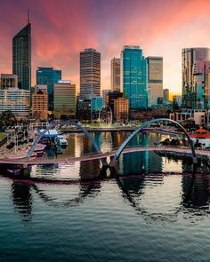 a bridge that is over some water in the middle of a city with tall buildings