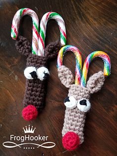 two crocheted candy canes are decorated like reindeer noses and nose with candy canes in their mouths