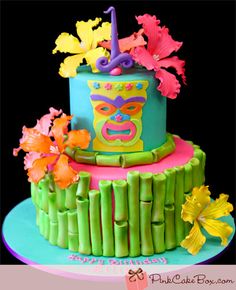 a colorful cake decorated with flowers and bamboo sticks