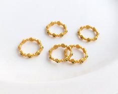 four gold rings sitting on top of a white plate