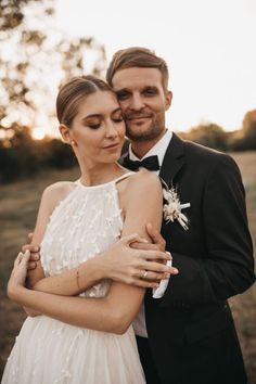 a man in a tuxedo and a woman in a wedding dress hugging each other