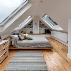 an attic bedroom with wooden floors and skylights