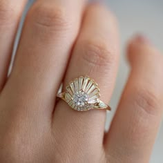 a woman's hand with a gold ring and diamond set in the middle, on top of her finger