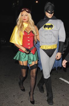 a man and woman dressed up as batman and robin wayne are walking down the street