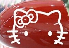 a hello kitty car sticker on the side of a red vehicle with white lettering