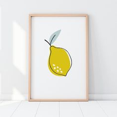 an art print of a lemon on a white wall next to a wooden framed frame