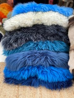 several different colored fur pillows stacked on top of each other