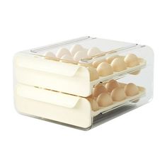 two trays filled with eggs sitting on top of each other in front of a white background