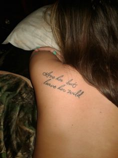 the back of a woman's shoulder with words written on it