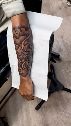 a man with a tattoo on his arm holding a piece of paper