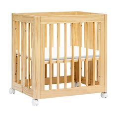 a small wooden crib with white sheets on the bottom and side rails, in front of a white background