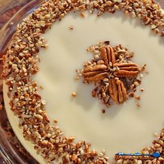 a cake with pecans on top and frosting