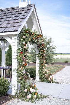 a small white building with flowers on it