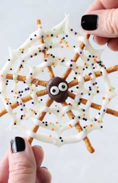 someone is holding up a cookie decorated like a spider