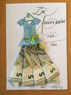 a dress made out of money sitting on top of a piece of paper