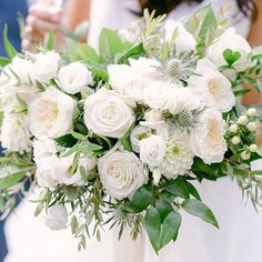 a bride holding a bouquet of white flowers