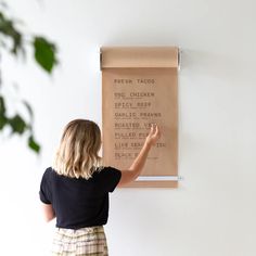 a woman is pointing to a menu on the wall