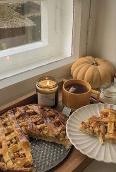 there is a pie on the table next to some candles and other items in front of it