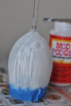 a whisk sitting on top of a newspaper next to a can of soda