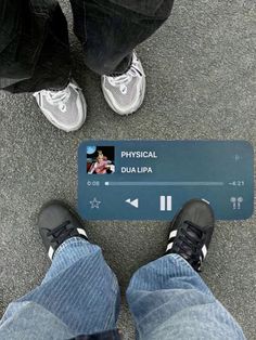 two people standing next to each other with their feet on a blue sign that says physical dua lipa