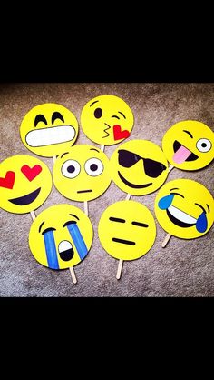 a bunch of smiley face cupcake toppers sitting on the floor with sunglasses and hearts