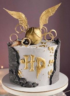 a white and gold decorated cake sitting on top of a table