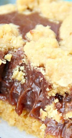 a close up of a piece of cake on a plate with chocolate sauce and crumbs