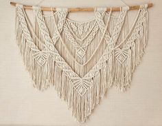 three macrame wall hangings on a white wall