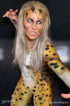 a woman dressed as a cheetah with her hands on her hips and one hand in the air