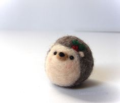 a small stuffed animal with a christmas decoration on it's head, sitting on a white surface