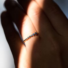 a woman's hand with a diamond ring on top of her finger, casting a shadow